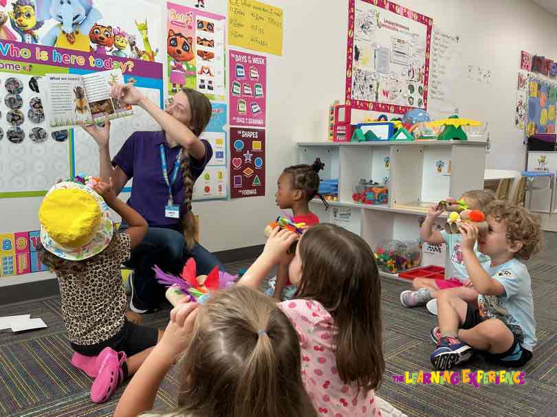 Adult reading a book to children in a classroom