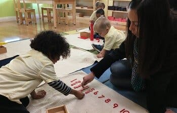 Adult and child learning numbers on a mat