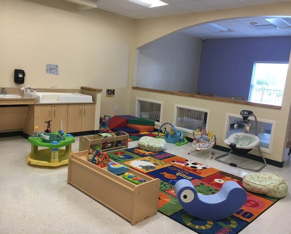 Infant and toddler play area with colorful rug and toys