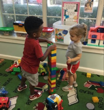 Two children playing with colorful building blocks