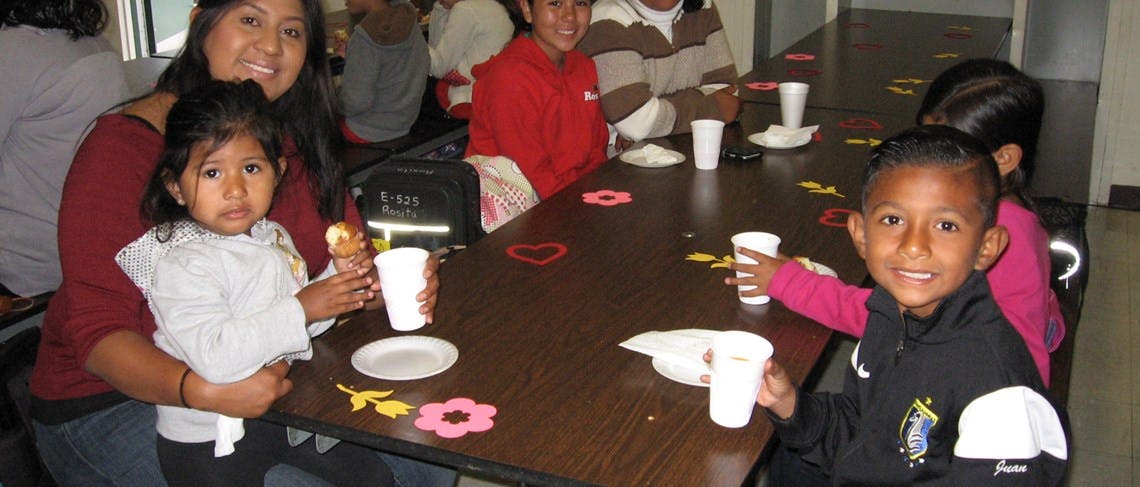 Person holding a child at a table with other children