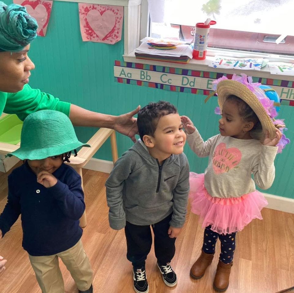 Person with two children in a classroom
