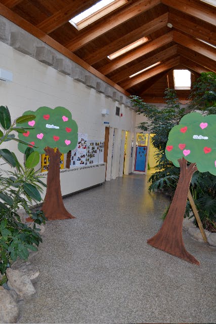 Hallway with wooden ceiling, skylights, and two decorative trees with hearts