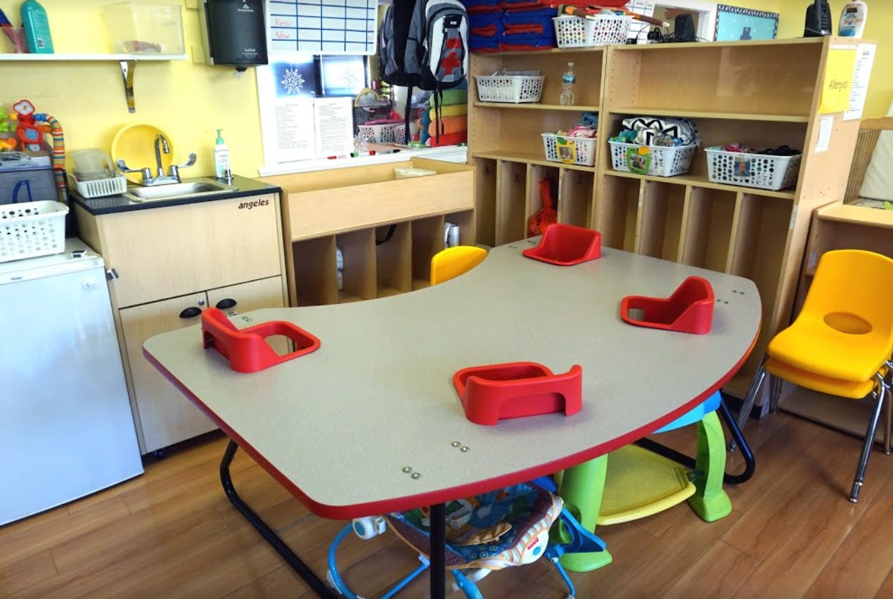 Classroom with a curved table and red child seats