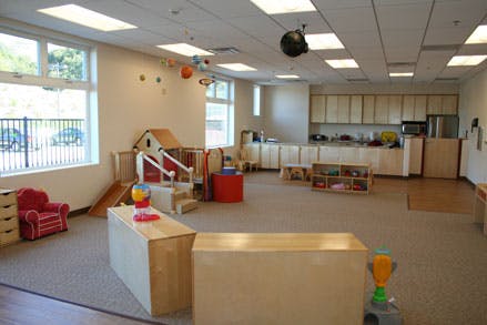 Empty classroom with play structures and kitchen area