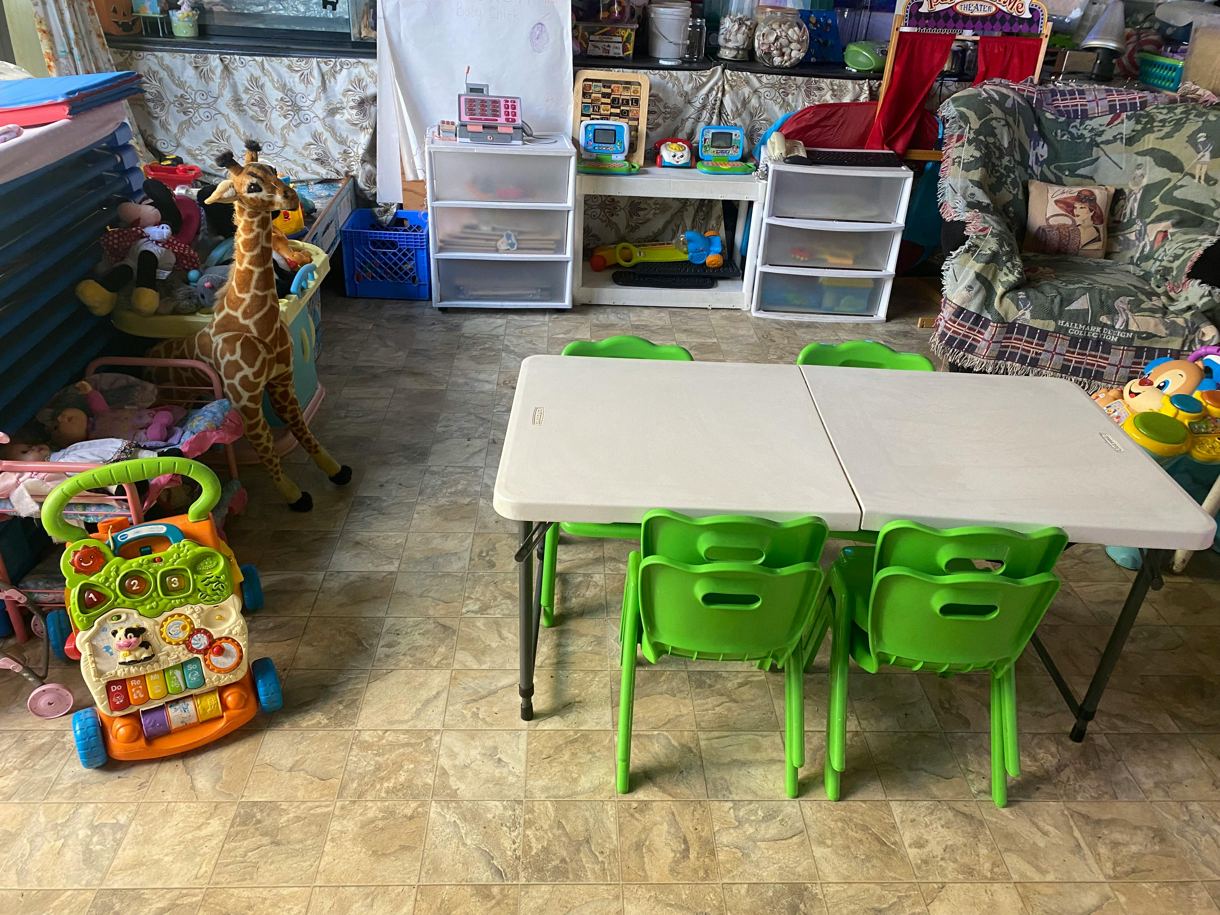 Children's table with green chairs in a room with toys
