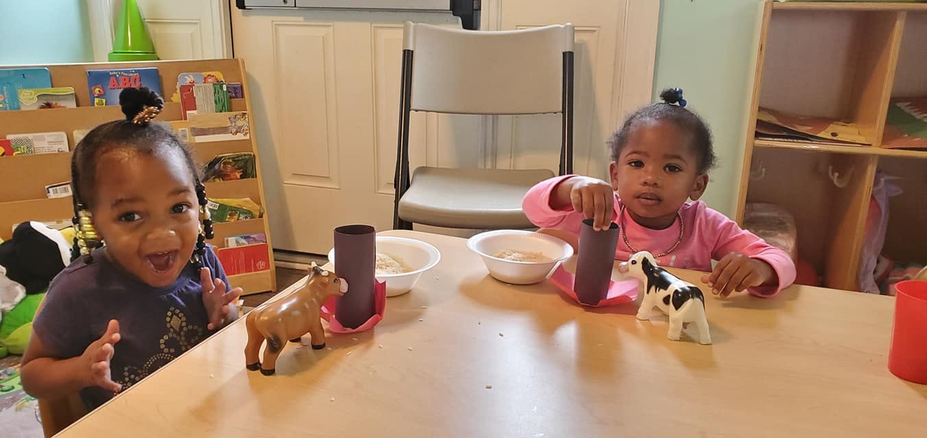 Two children playing with toys at a table