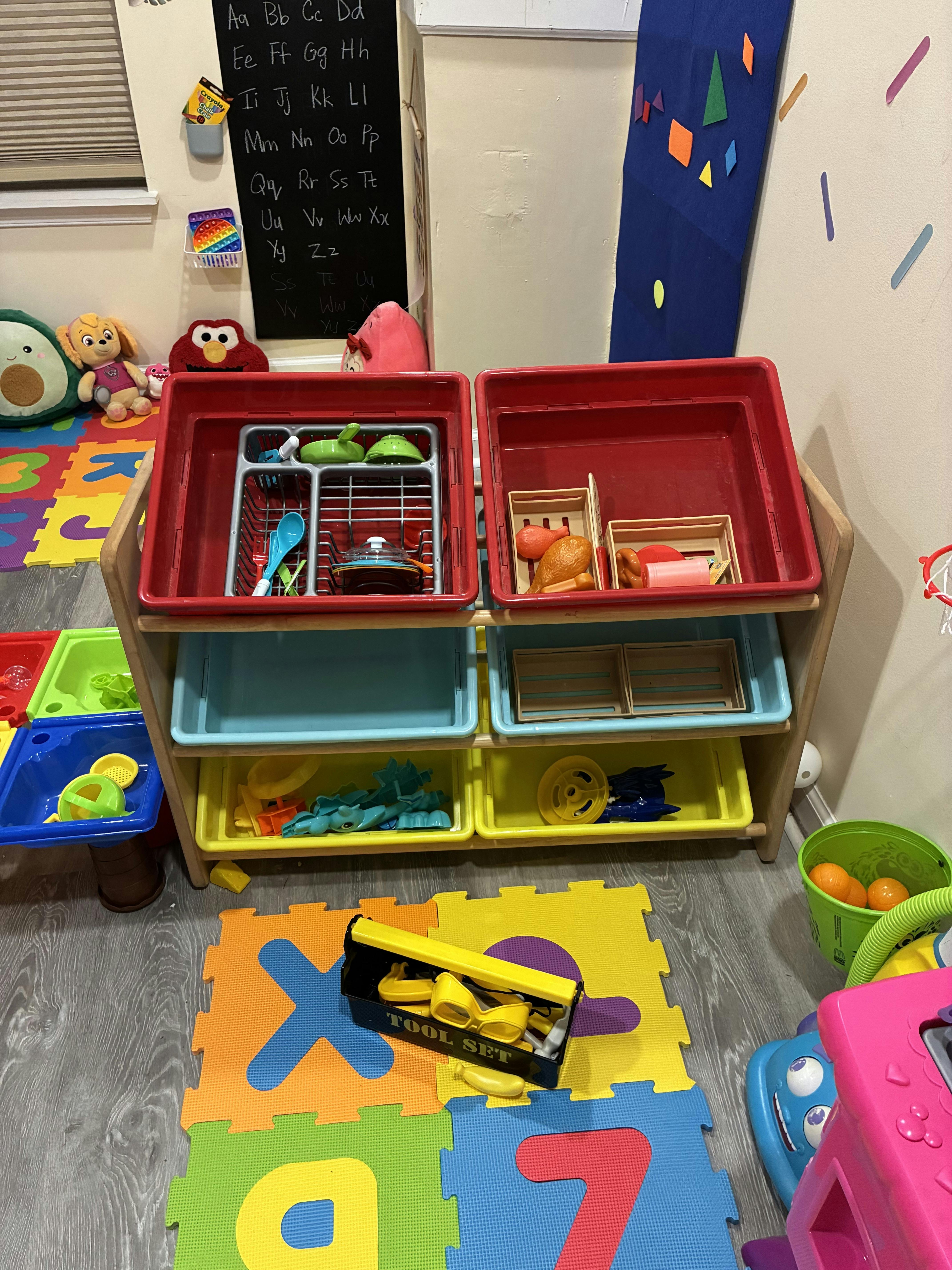 A wooden shelf with multiple bins filled with children's play toys