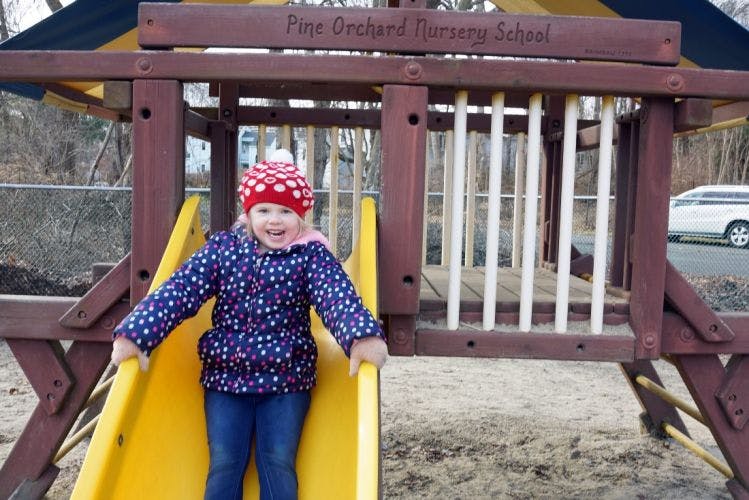 Child on a yellow slide at a playground