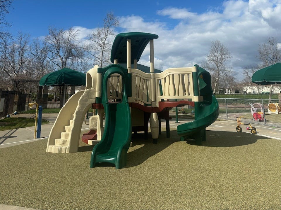 A large playground structure with slides and climbing areas on a soft ground