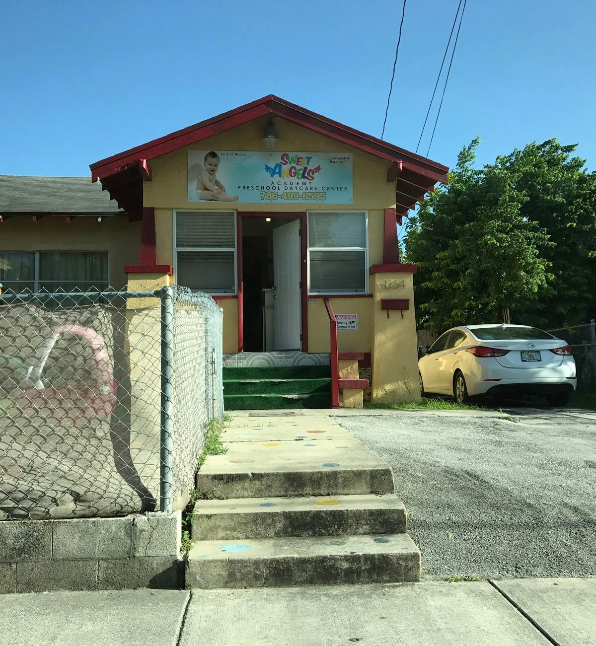 Building with a sign that reads "Baby Angels" and a white car parked nearby
