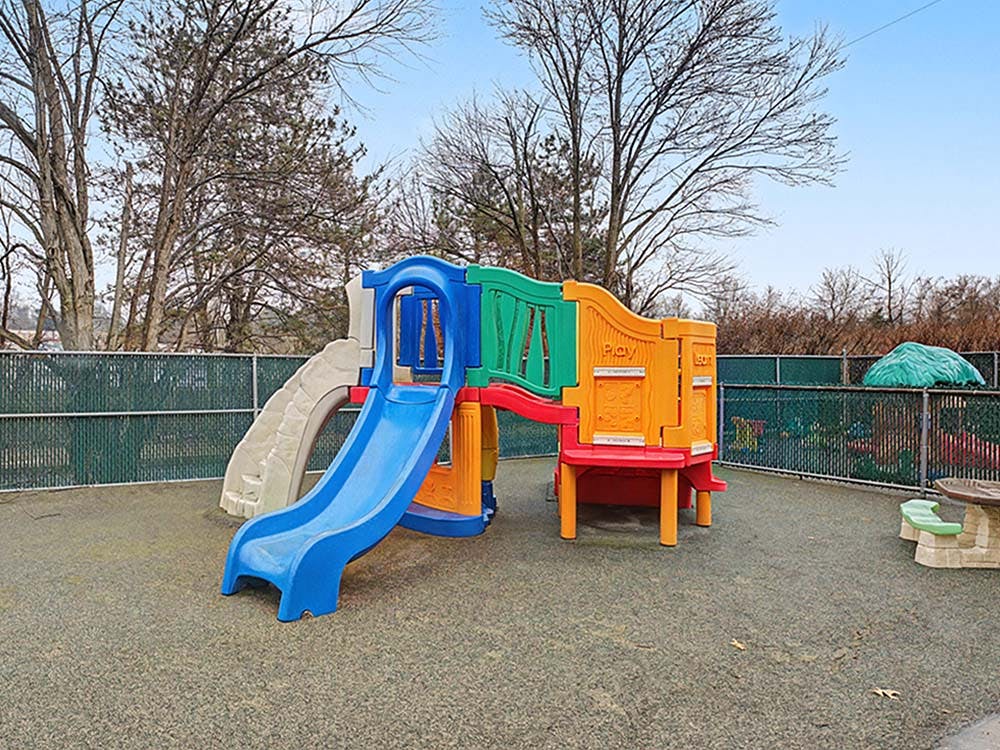 Colorful playground structure with slides on a rubberized surface