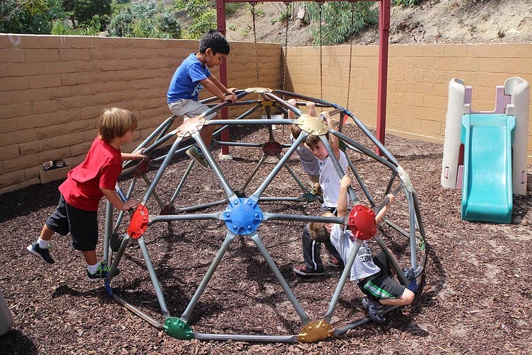 Children playing on a geodesic dome climber