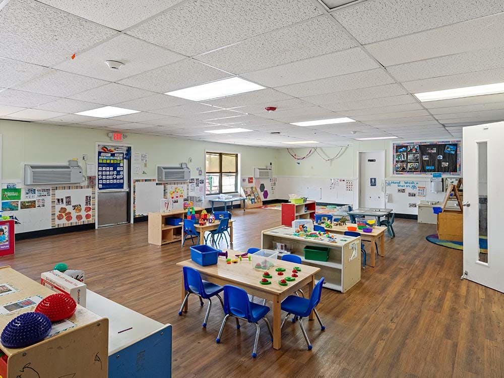 Empty colorful classroom with small tables and chairs