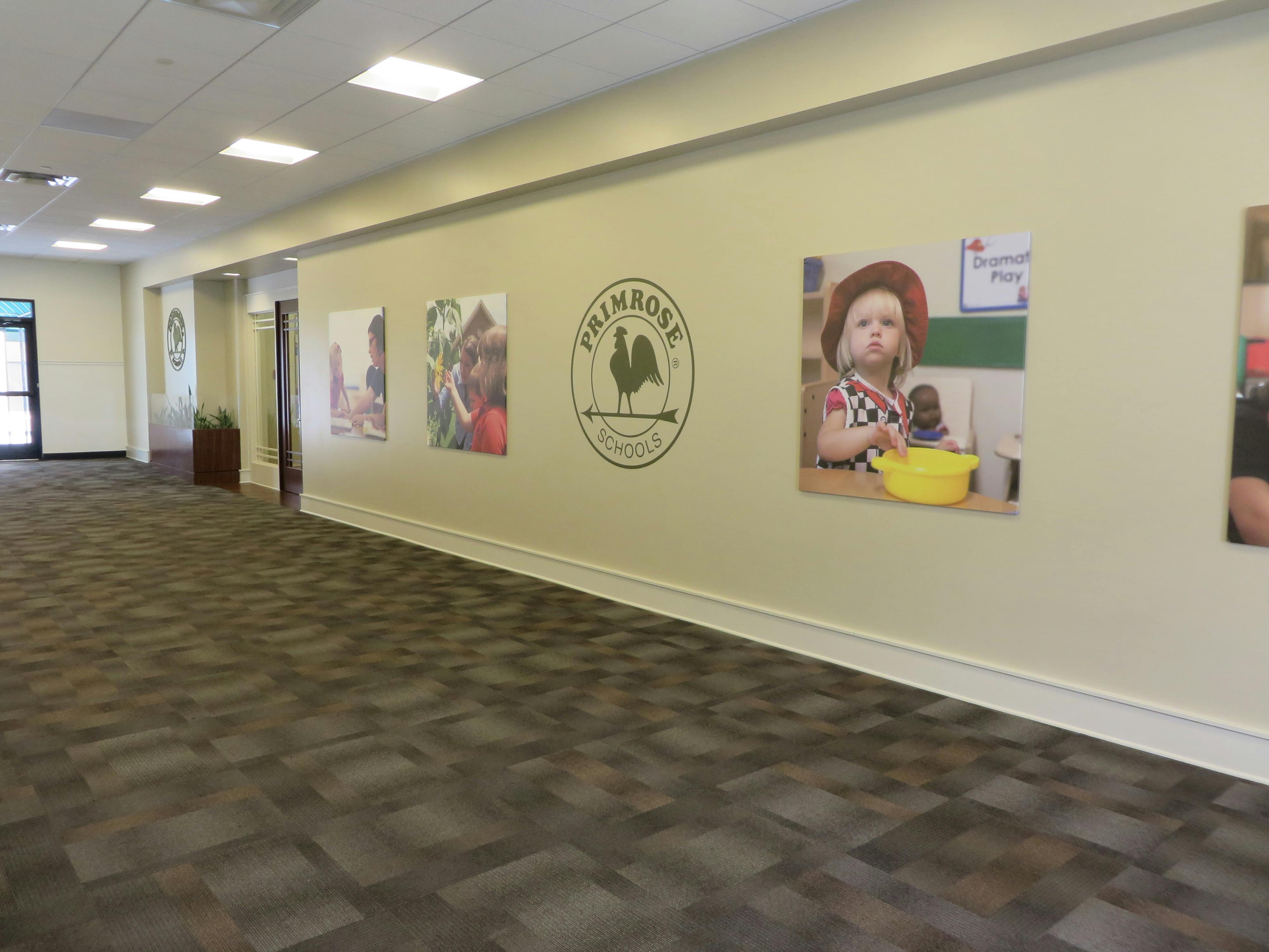 Hallway with framed pictures and a logo on the wall