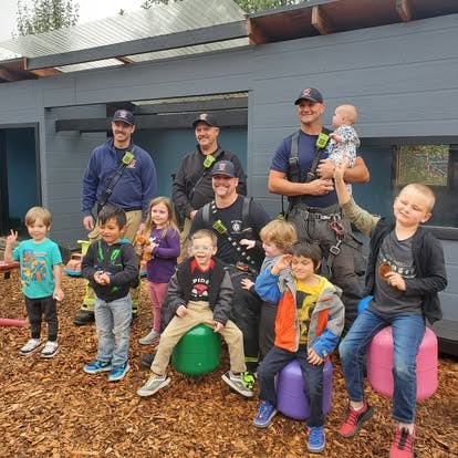 Adults in uniform with children outdoors