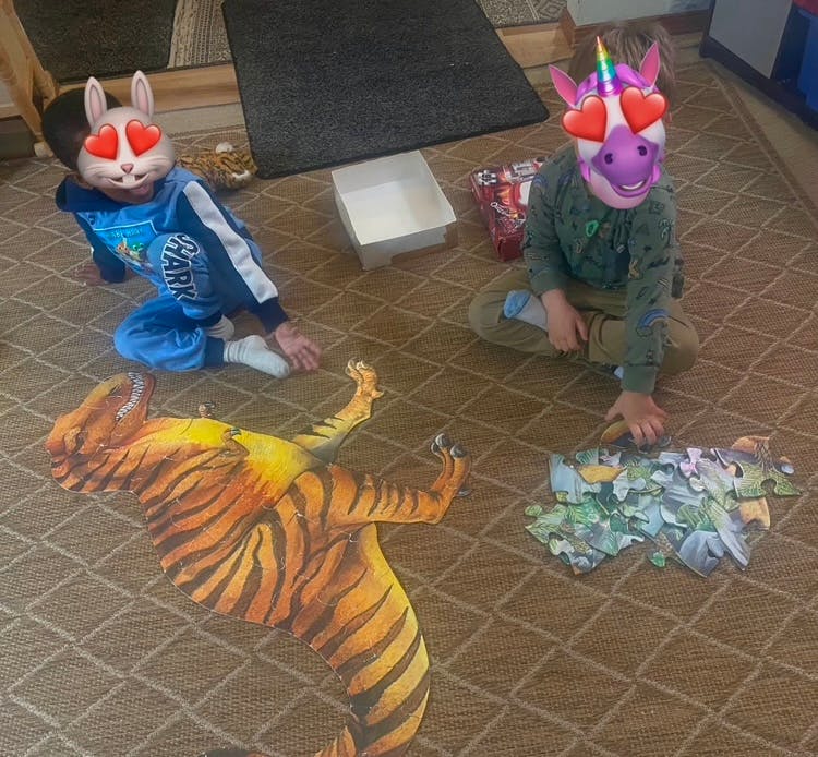 Two children playing with puzzles on the floor