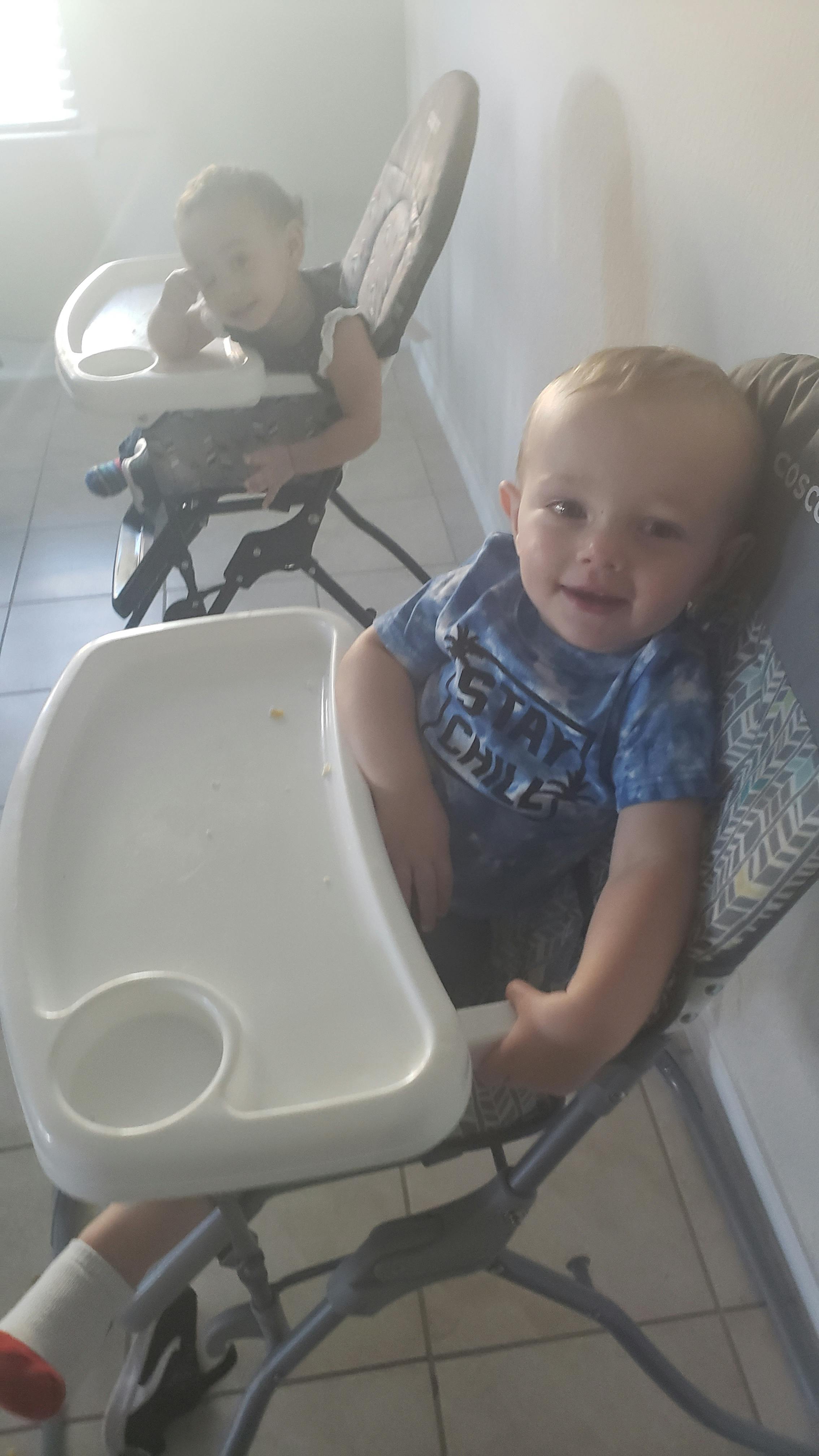 Two children sitting in high chairs