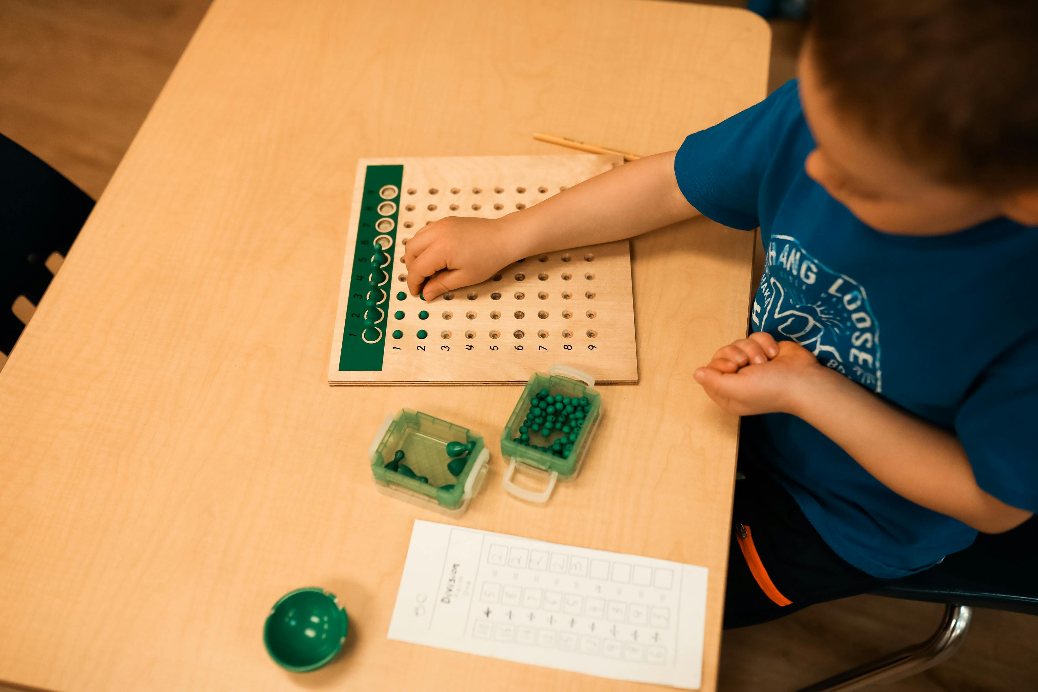 Child using a multiplication board at a desk