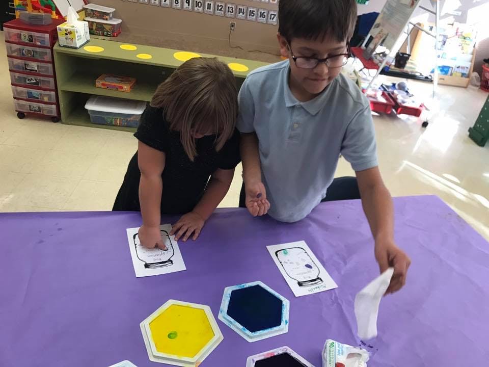 Two children working on a project at a table