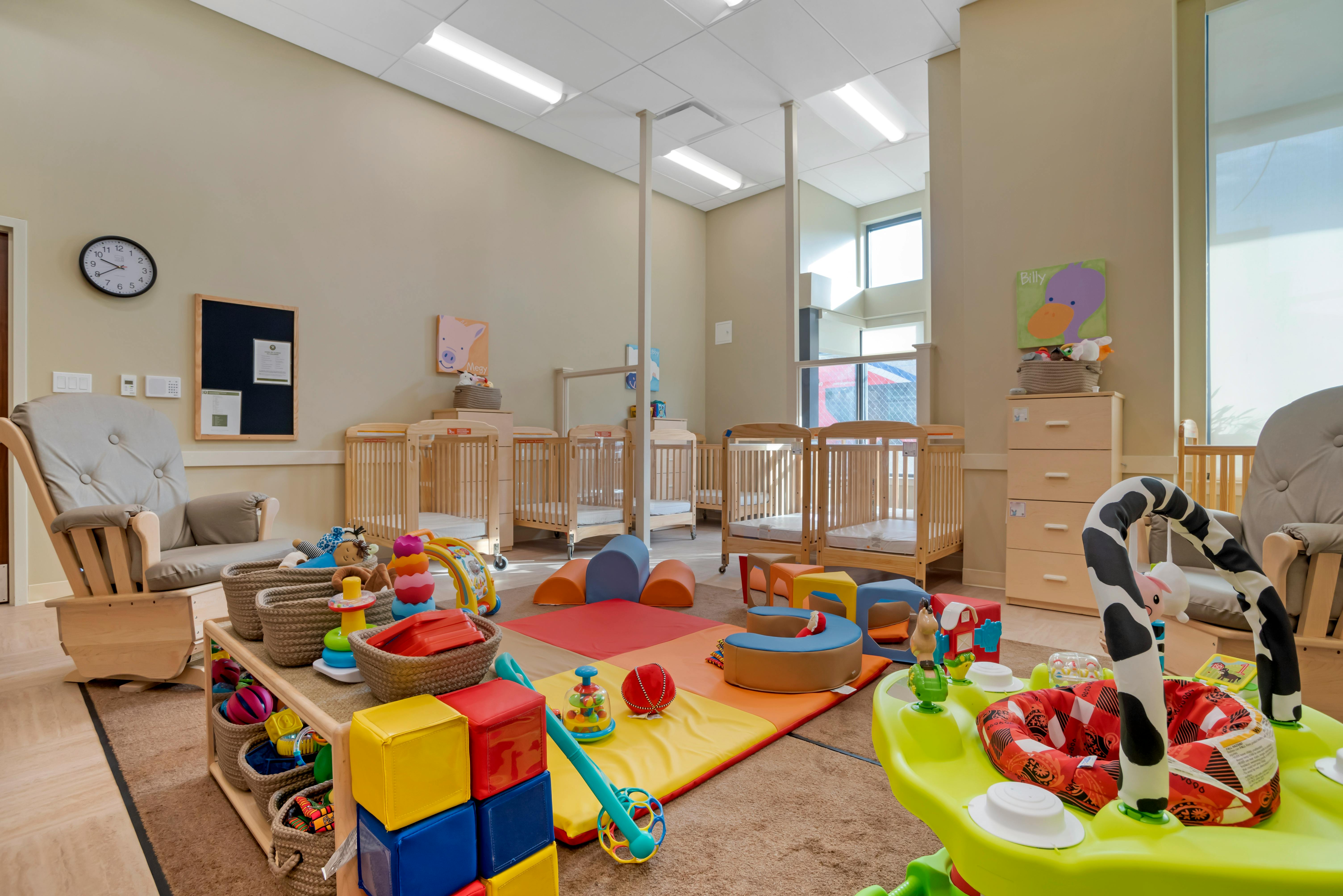 cribs and colorful toys in a daycare room