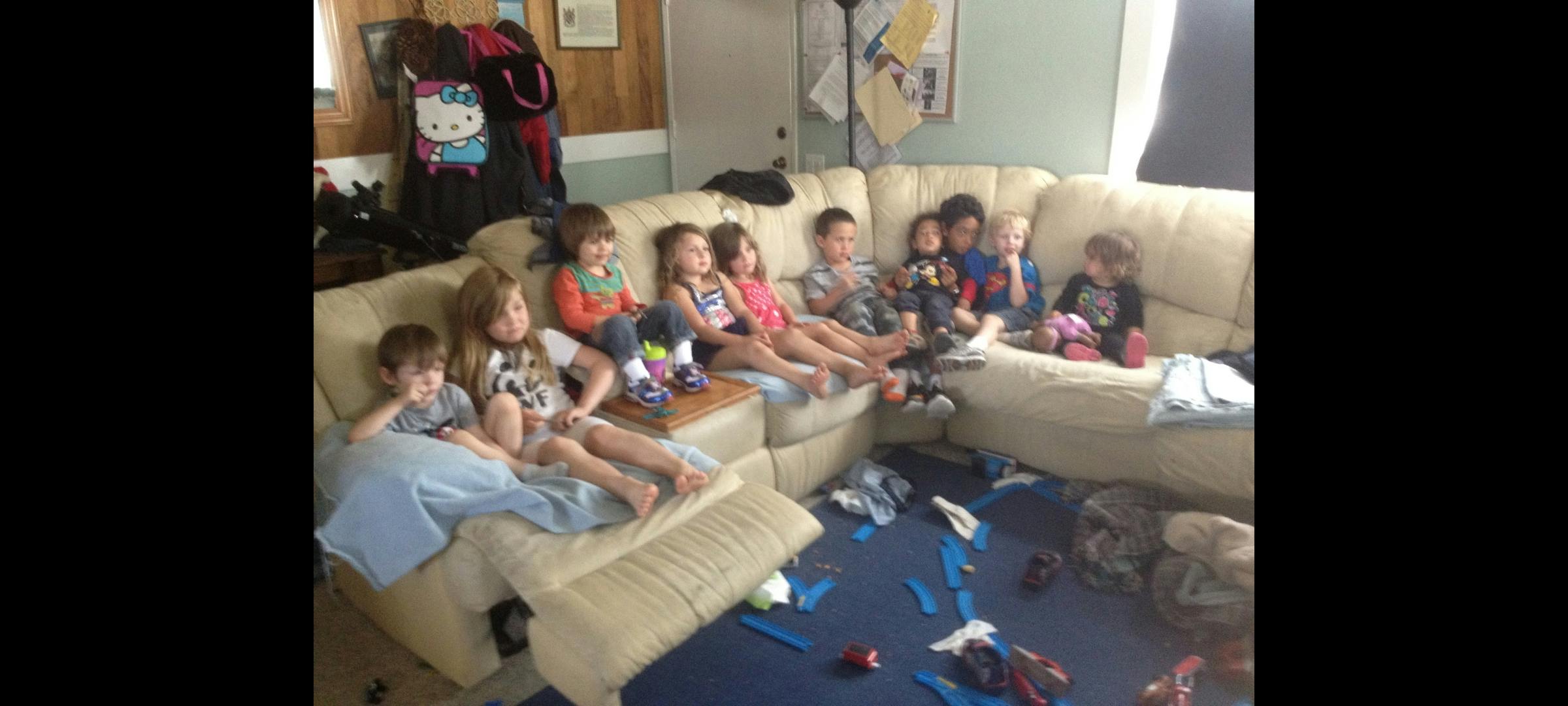 Group of children seated on a large L-shaped couch