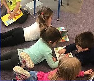 Children lying on floor reading books