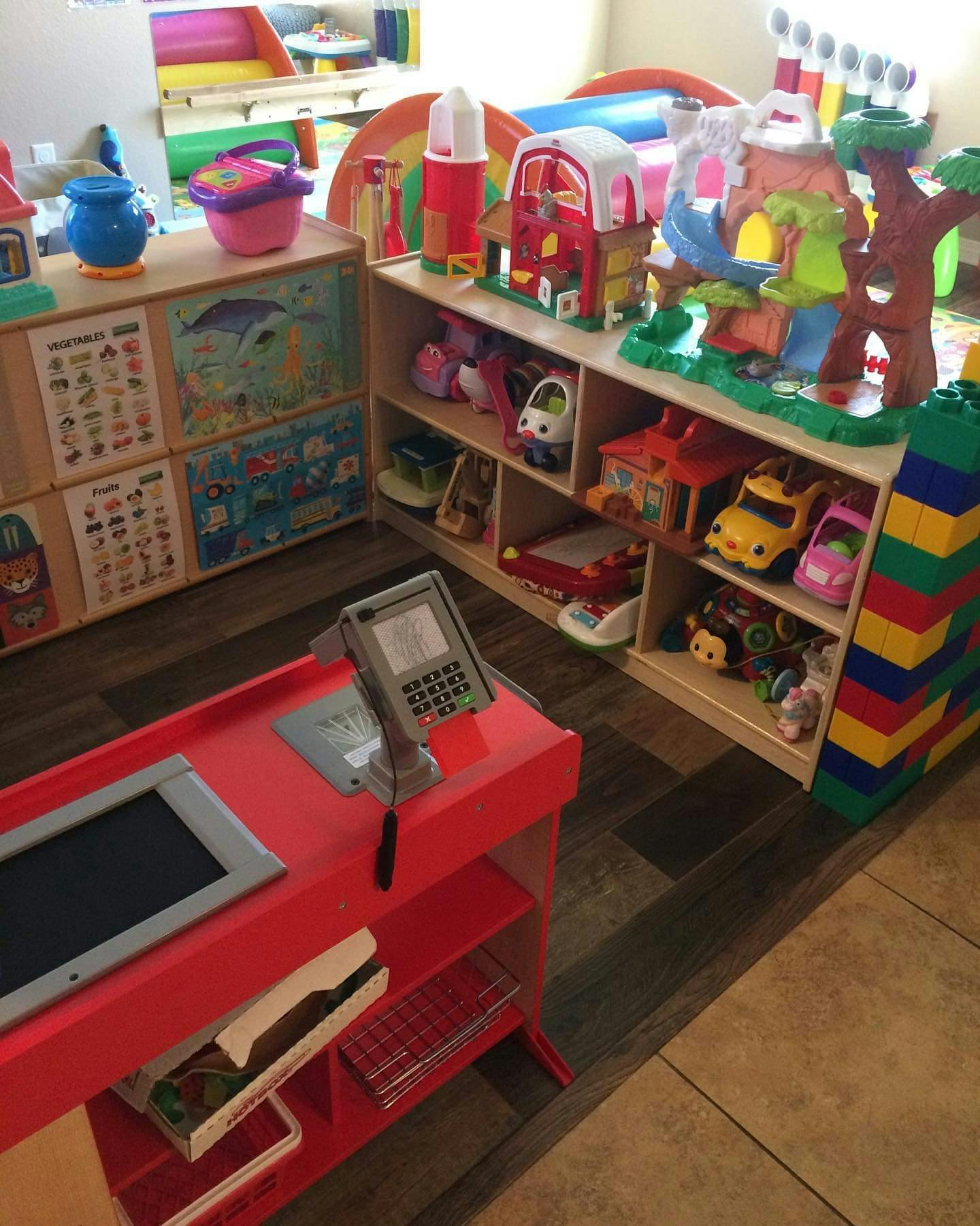 Playroom with toy cash register and shelves of toys