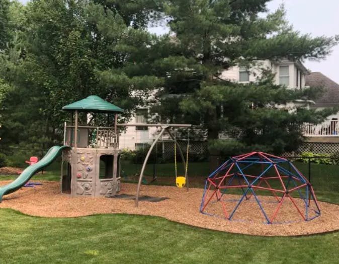 Outdoor playground with slide, swings, and climbing dome