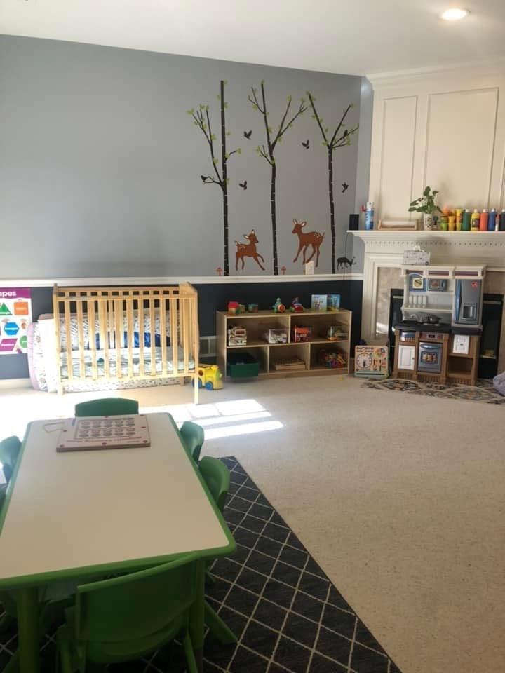 Playroom with crib, small table and chairs, and toy kitchen