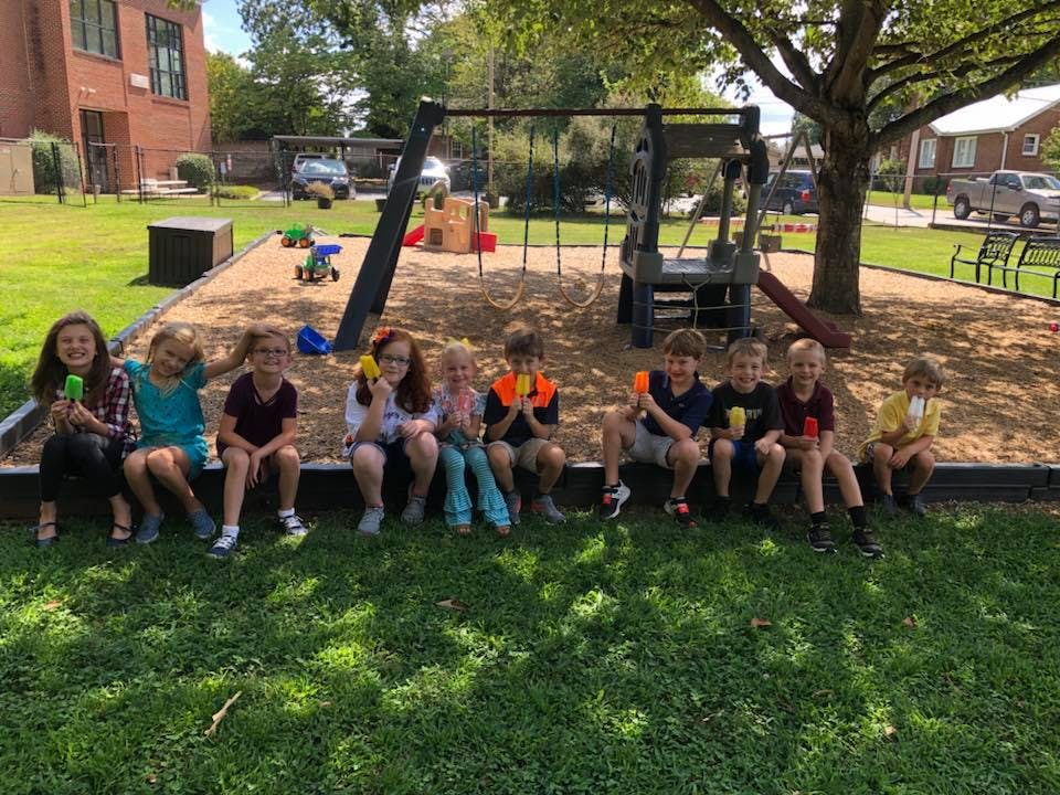 Group of children sitting on the edge of a playground