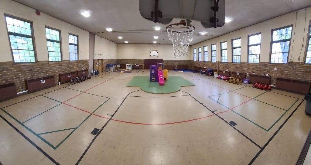 Empty gymnasium with basketball hoops and play equipment