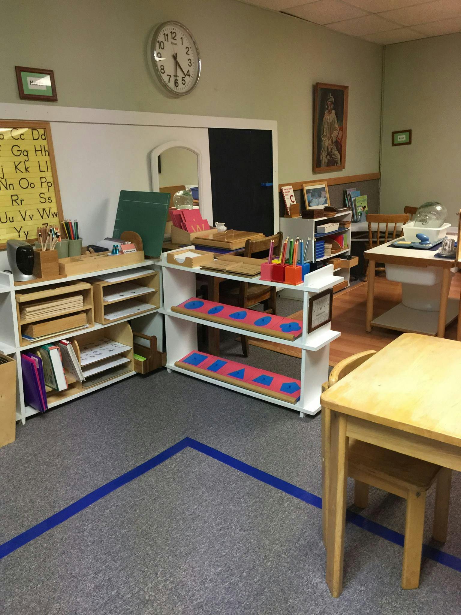 Classroom with shelves of learning materials and small tables