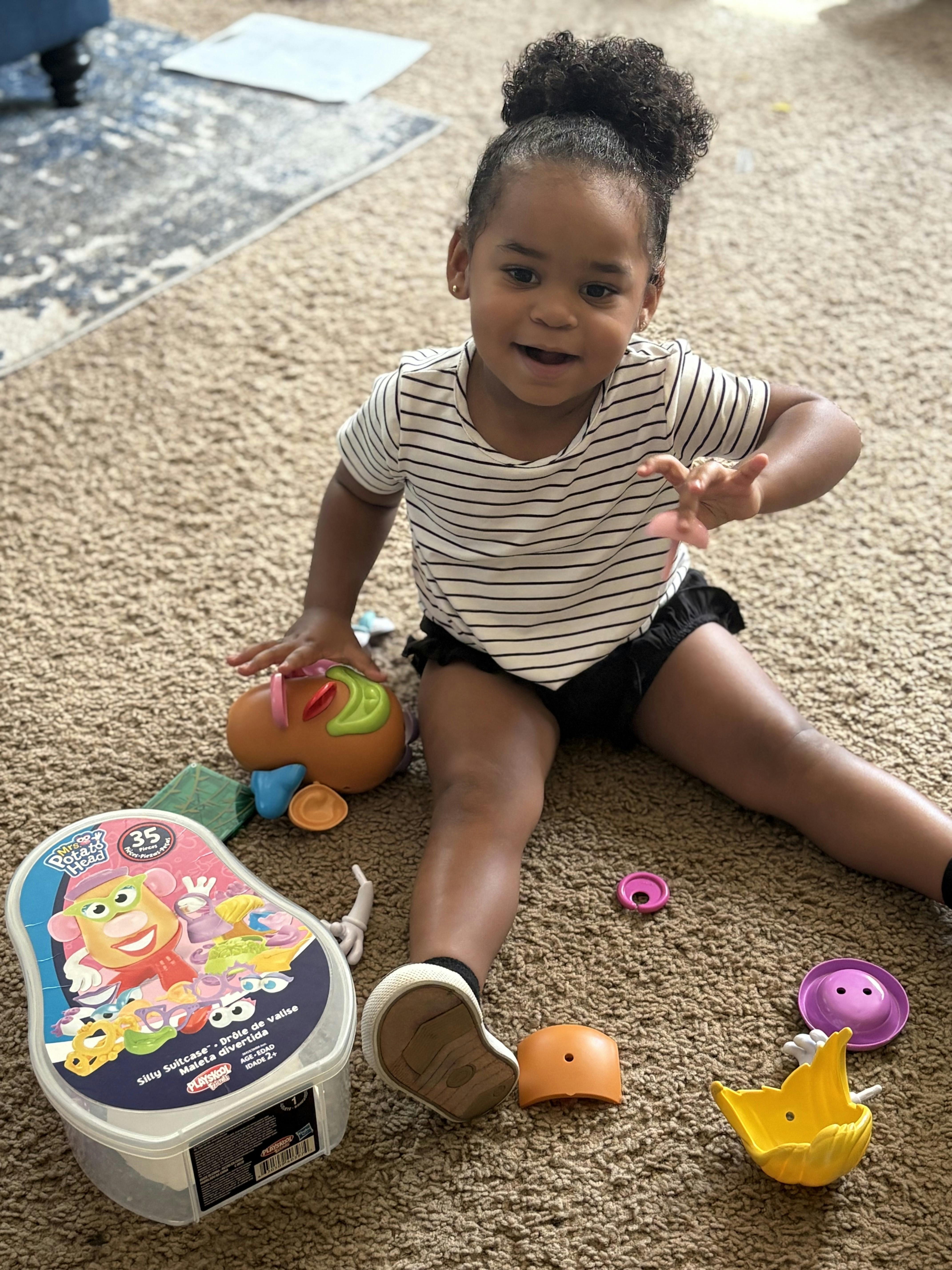 Child sitting on carpet playing with toys