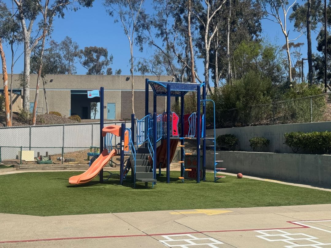 Empty outdoor playground with a slide and climbing structures