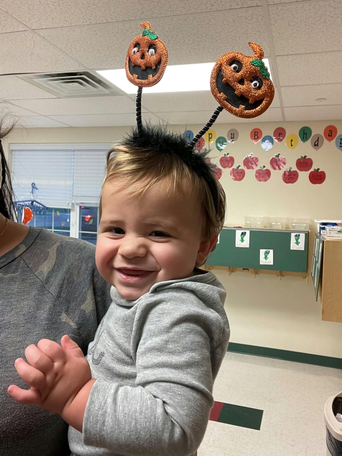 Child wearing a pumpkin headband
