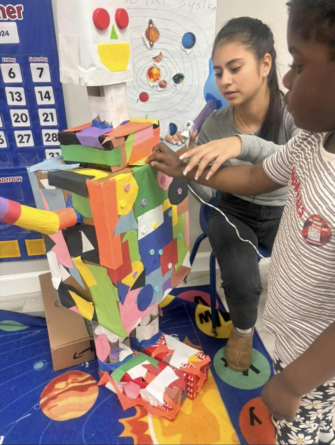 Person and child building a colorful cardboard robot