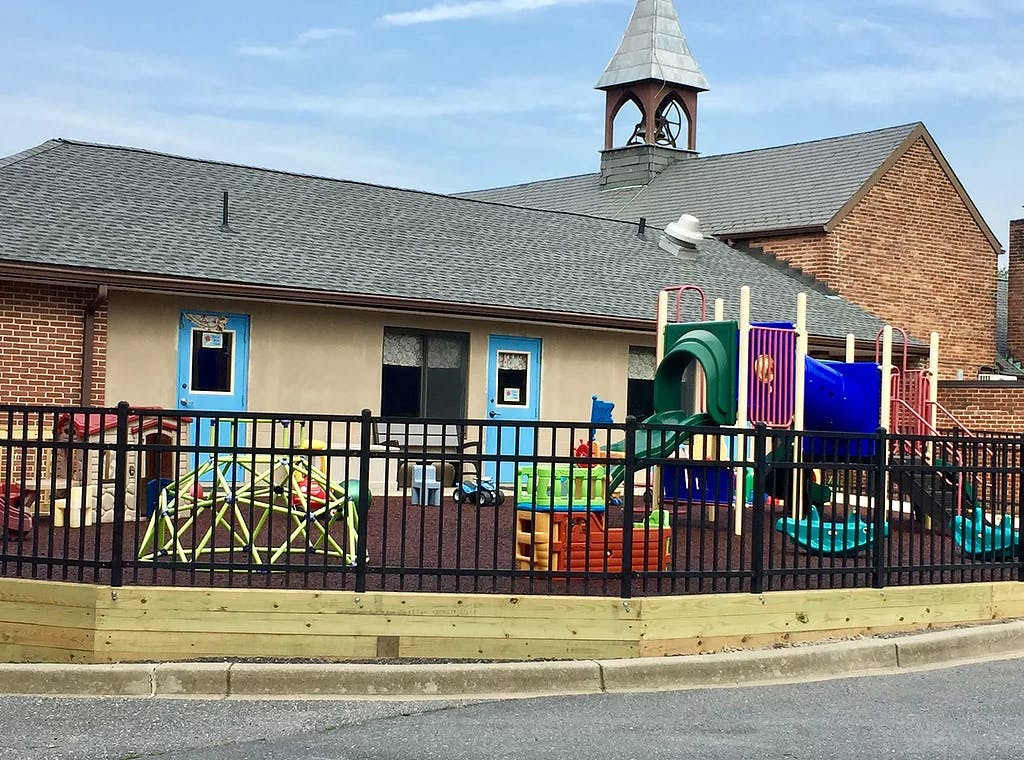 Playground with colorful equipment behind a black fence