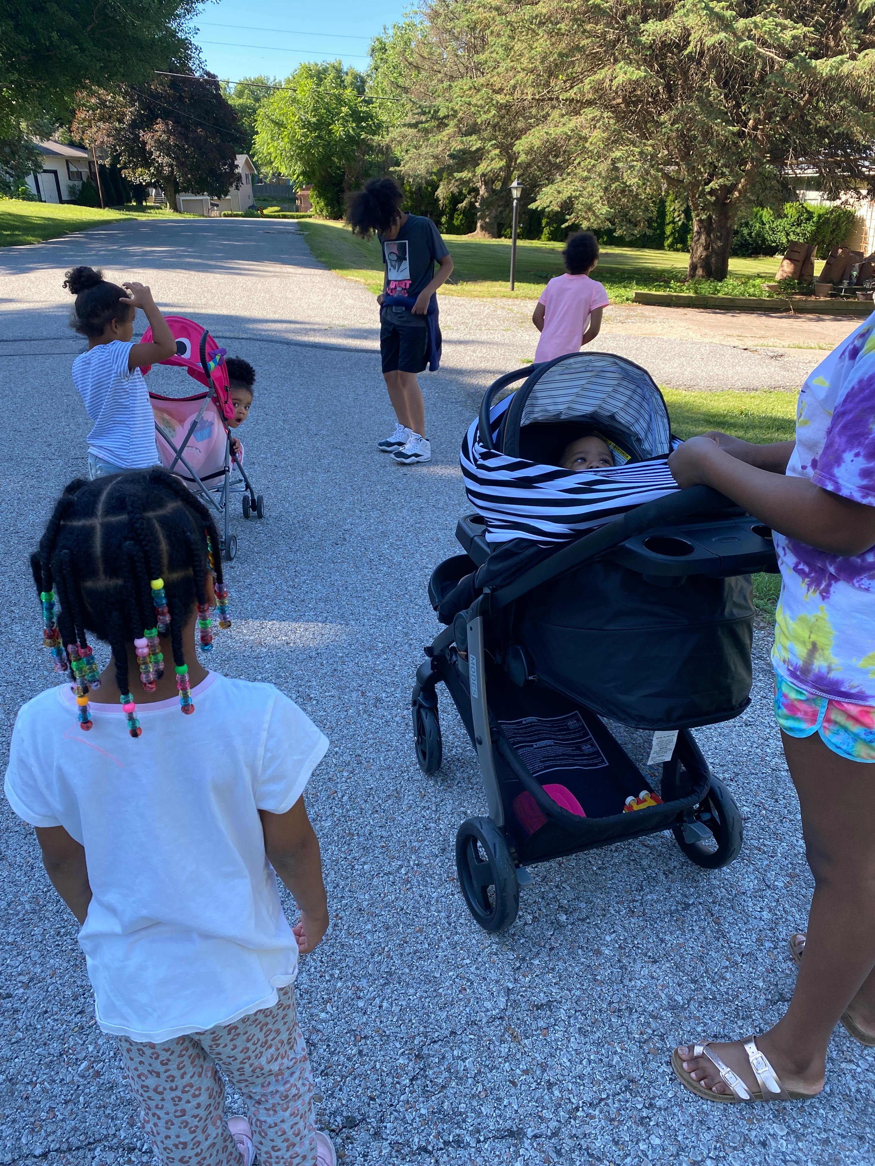 People and children on a street with a stroller