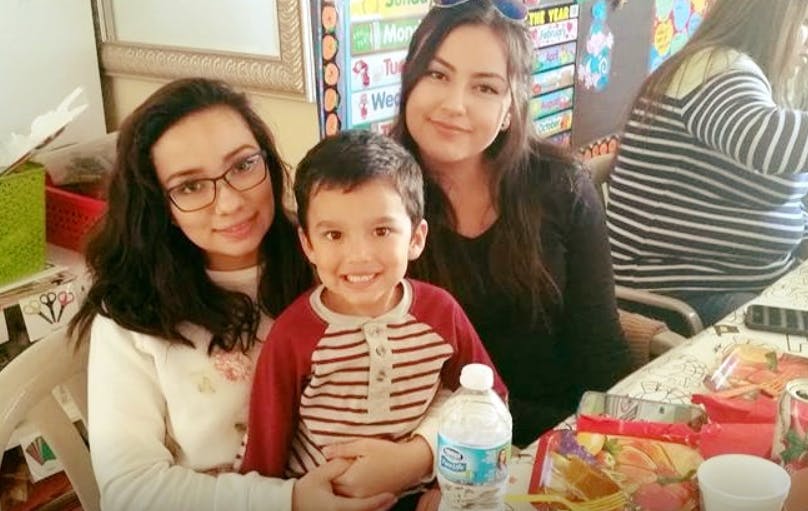 Two people and a child smiling