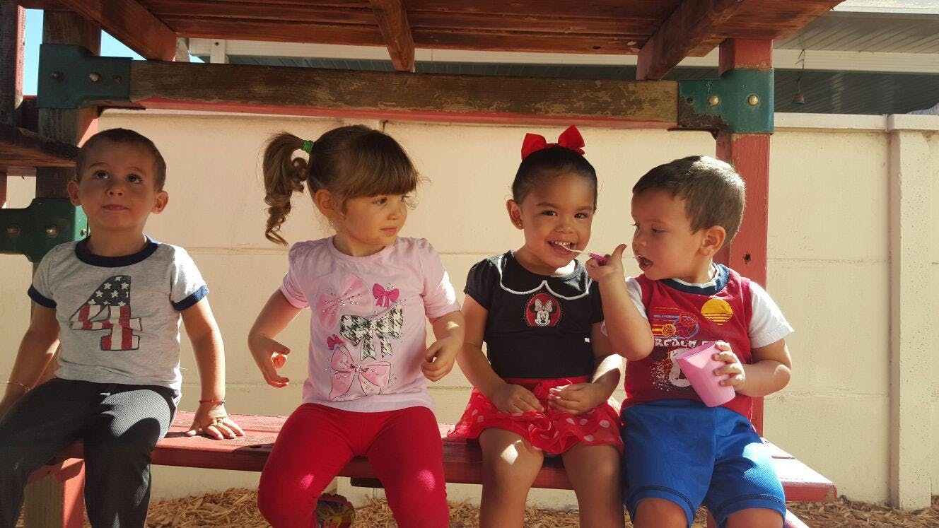 Four children sitting on a bench