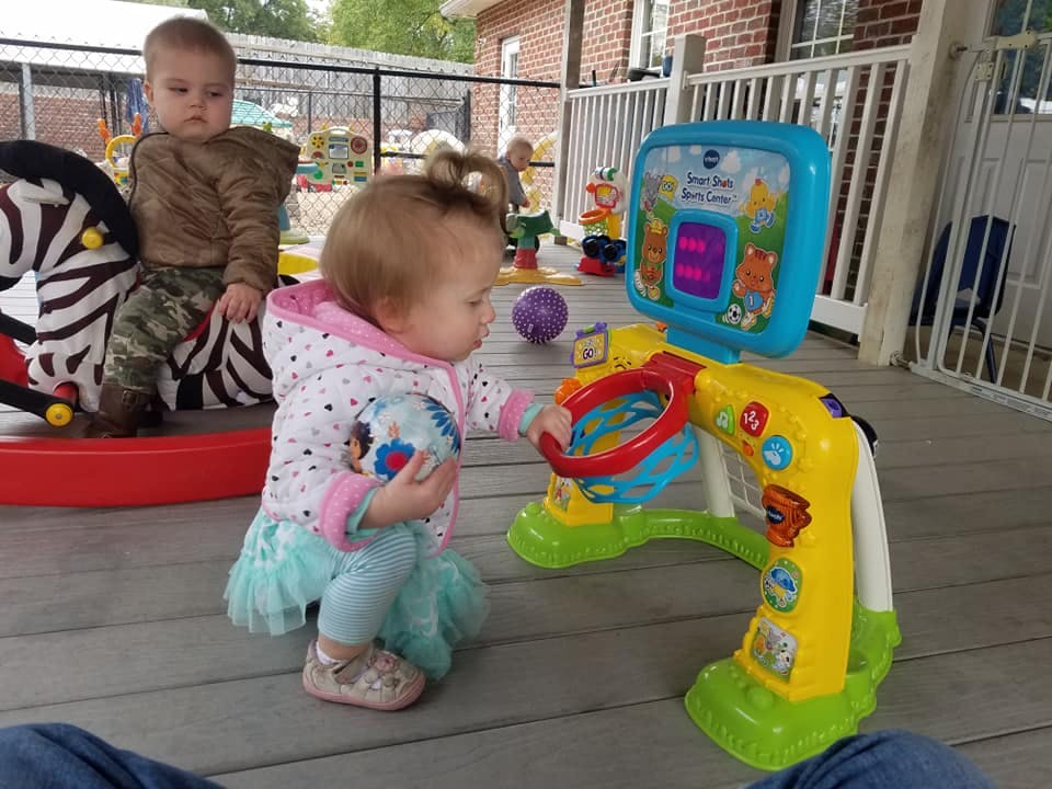 Two children playing with toys on a porch