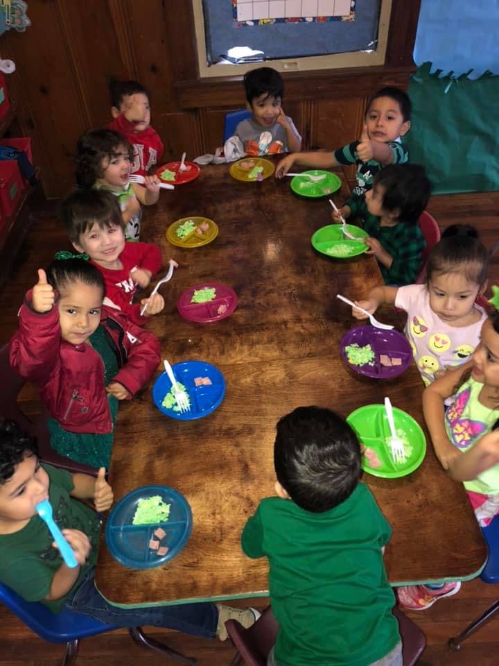 Children sitting around a table with plates and utensils