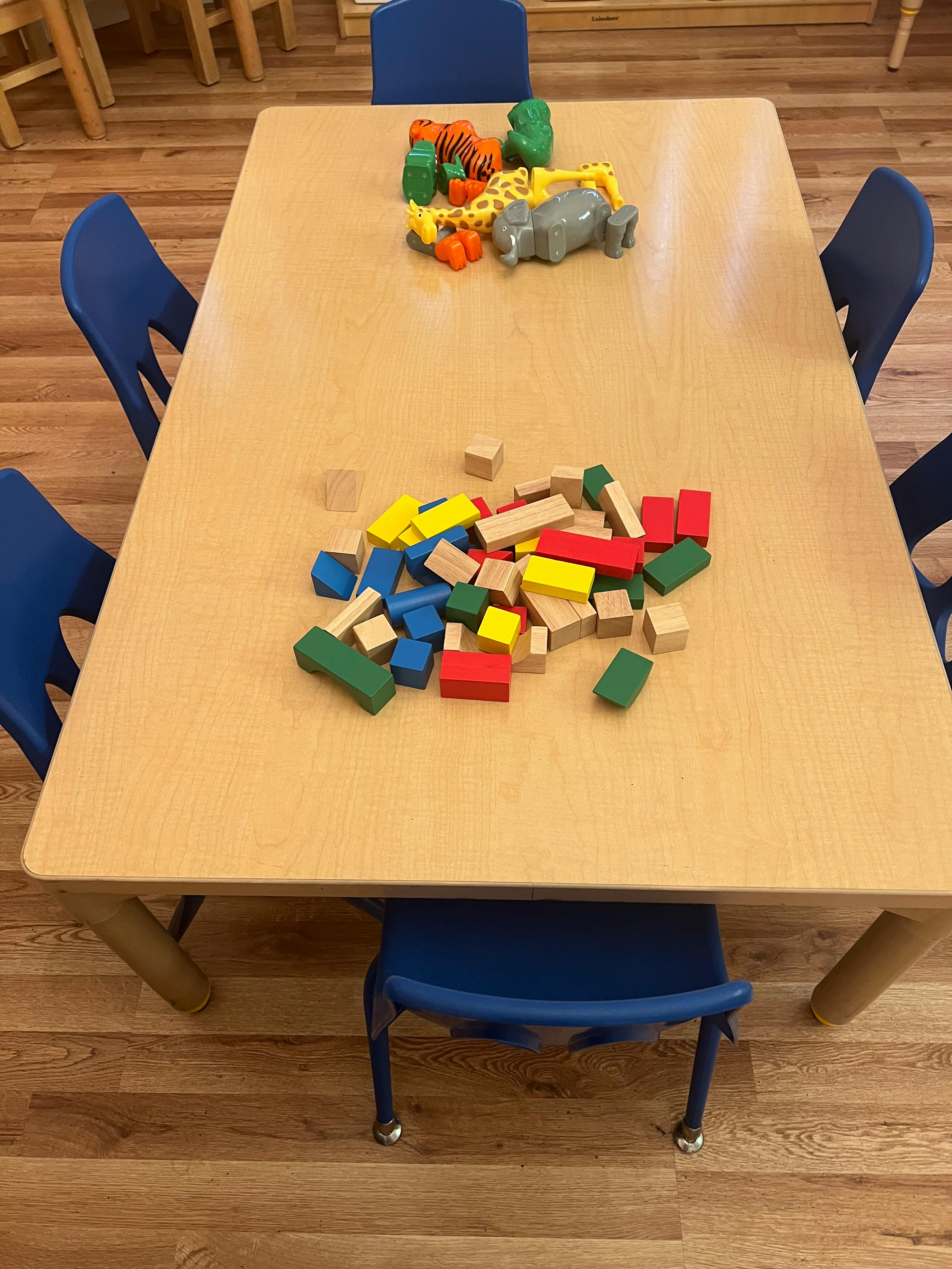 Wooden table with colorful building blocks and animal toys