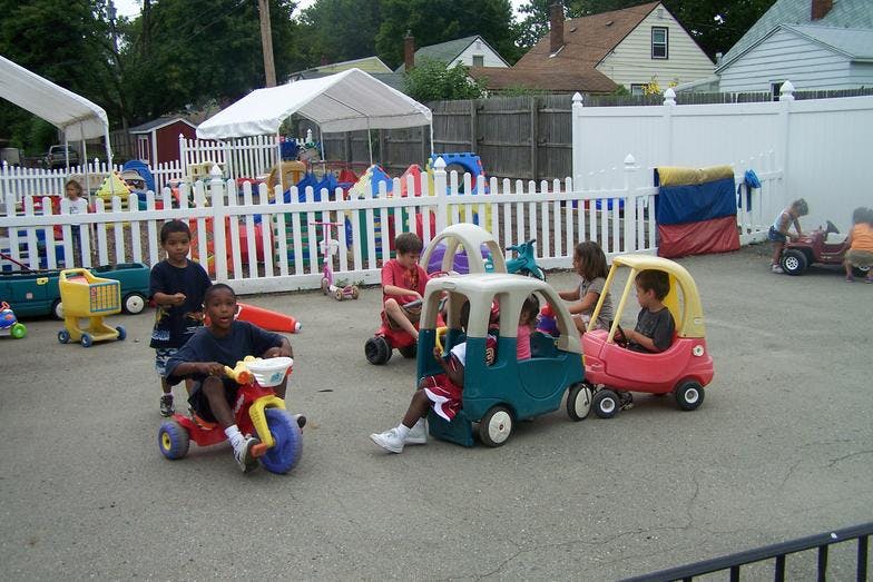 Children playing with ride-on toys in an outdoor area
