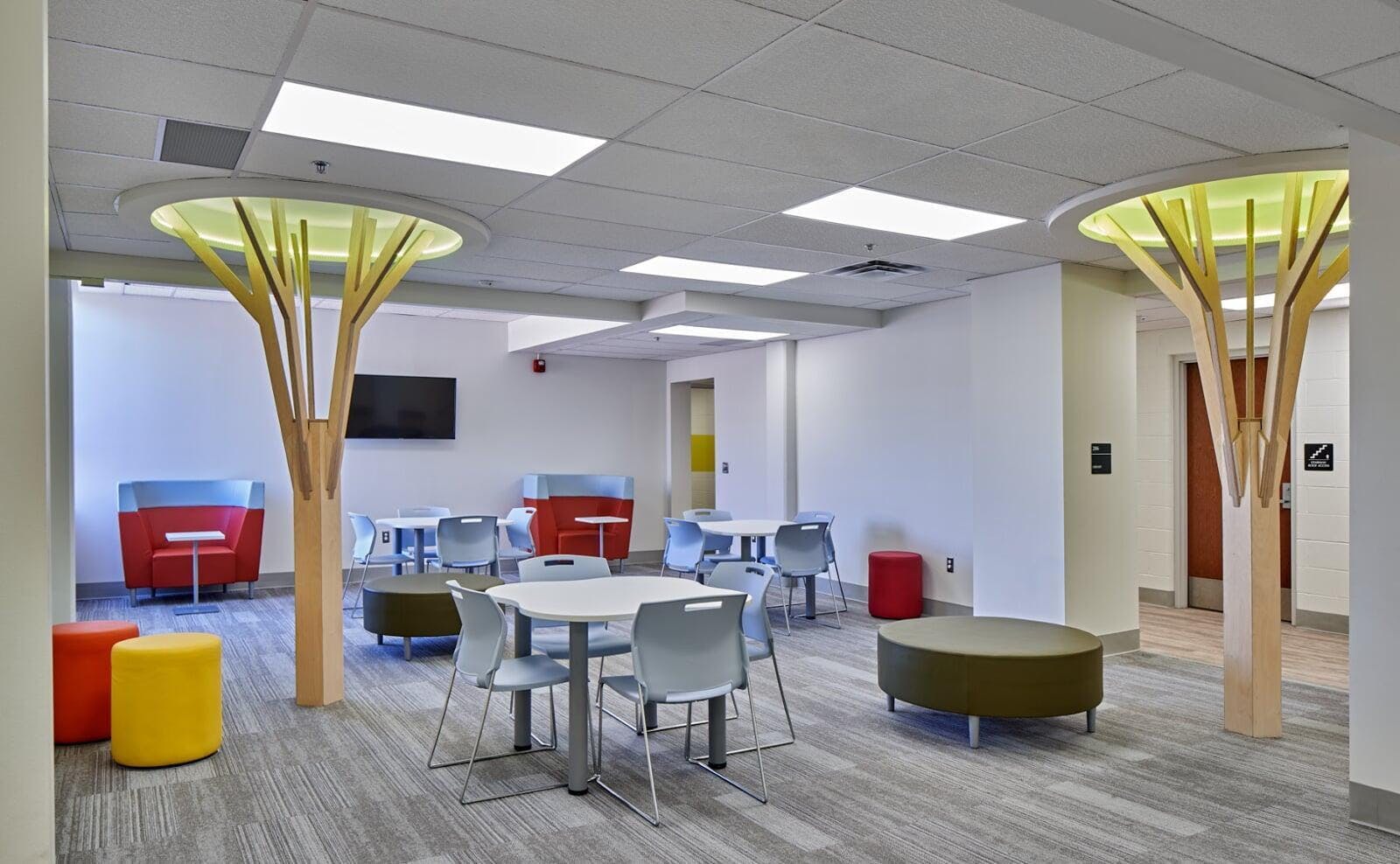 Lounge area with tables, chairs, and decorative tree-like structures