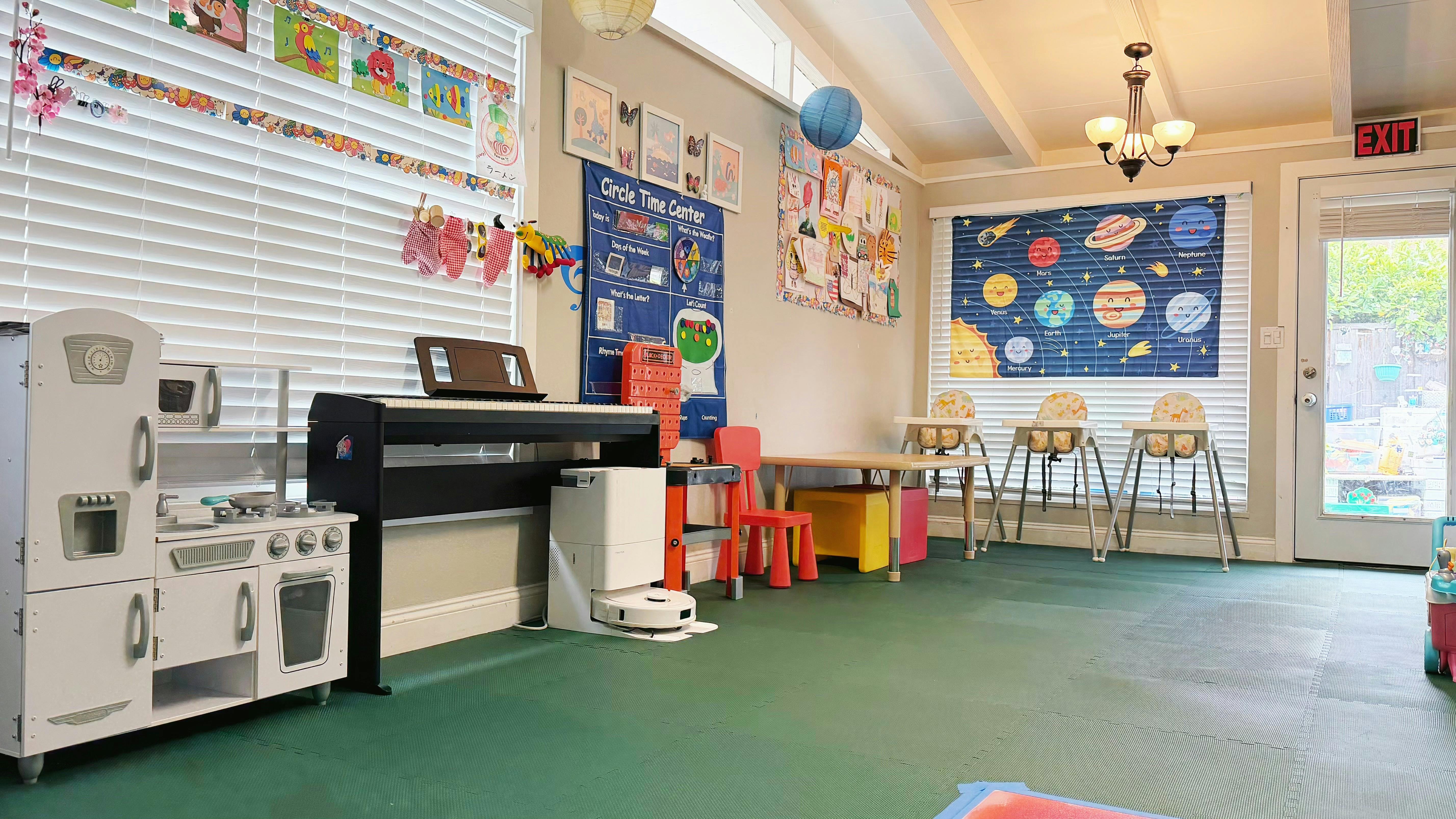 Children's play area with a toy kitchen, piano, and learning posters