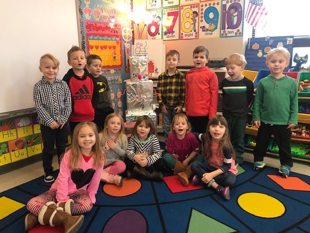 Group of children posing in a classroom