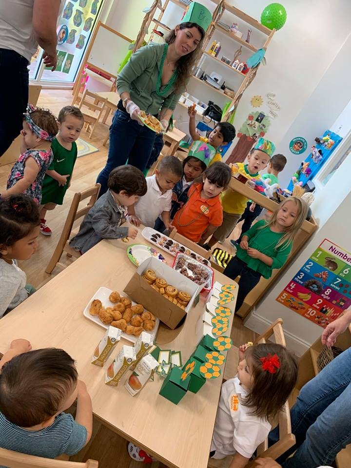Adult serving food to children in a classroom