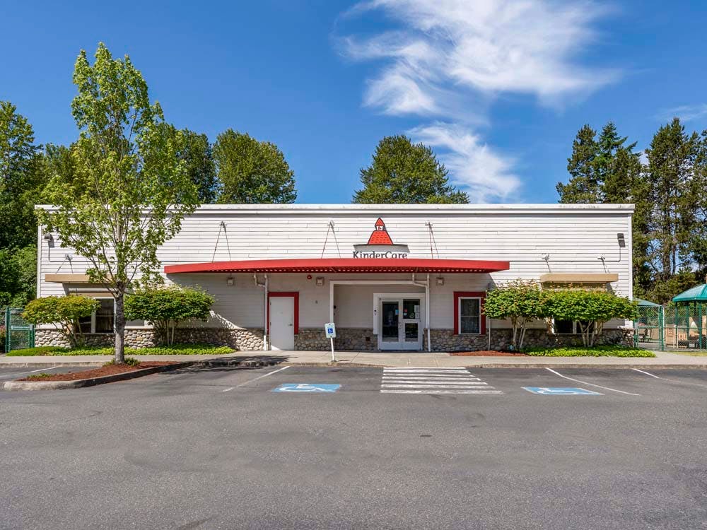 KinderCare building with a red awning and a small playground to the right